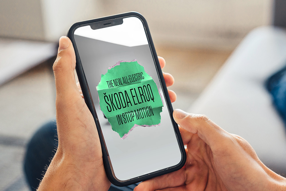 Hands holding a phone showing the Škoda Elroq stop-motion film